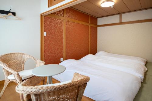 a bedroom with a bed and a table and chairs at Villa Shigin in Nakafurano
