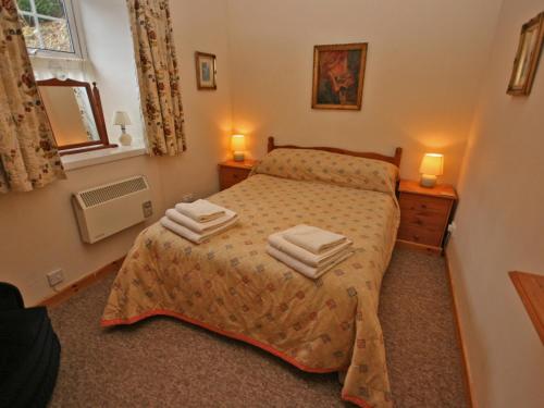 a bedroom with a bed with two towels on it at Lochview Barn in Strathyre