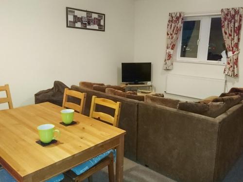 a living room with a couch and a table at Belle Isle Cottage in Haworth