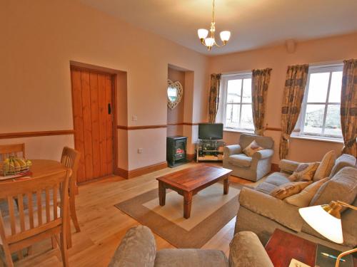 a living room with a couch and a table at Granary Cottage Whittingham in Whittingham