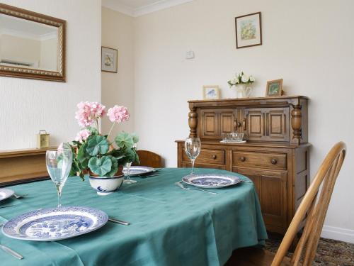 a table with a blue table cloth and a vase of flowers at Rose Garth in Robin Hood's Bay