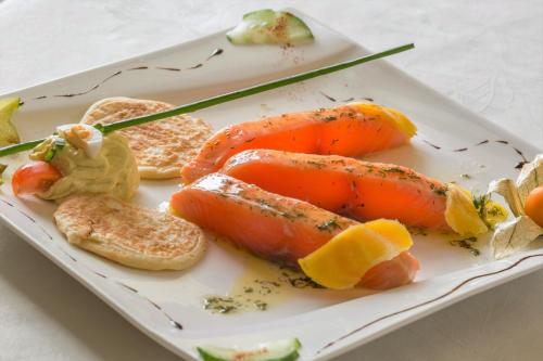 a plate of food with carrots and bread at Auberge Du Cheval Blanc in Beaumont-Pied-de-Boeuf
