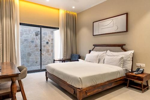 a bedroom with a bed and a desk and a window at KMR Hotels & Resorts in Bikaner