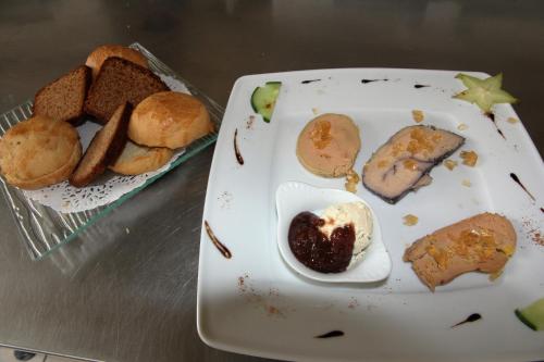 a plate of food on a table with a plate of food at Auberge Du Cheval Blanc in Beaumont-Pied-de-Boeuf