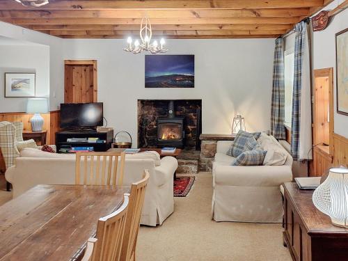 a living room with a table and a fireplace at Sanctuary Cottage in Applecross