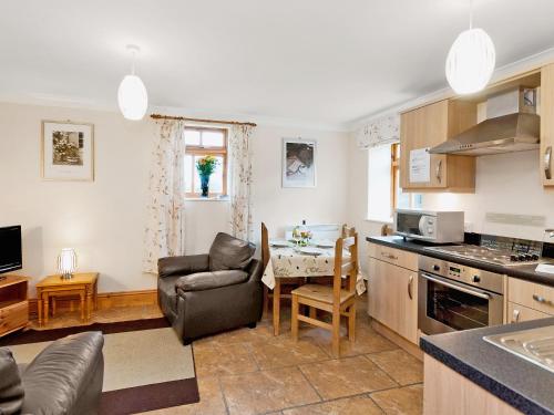 a kitchen and living room with a couch and a table at Trueman - W41948 in Filey