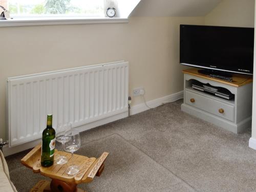 a living room with a flat screen tv and a table at The Smithy in Ovingham