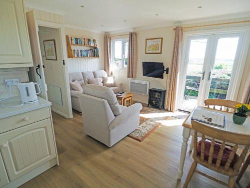a living room with a couch and a table at Ash Lodge in Nawton