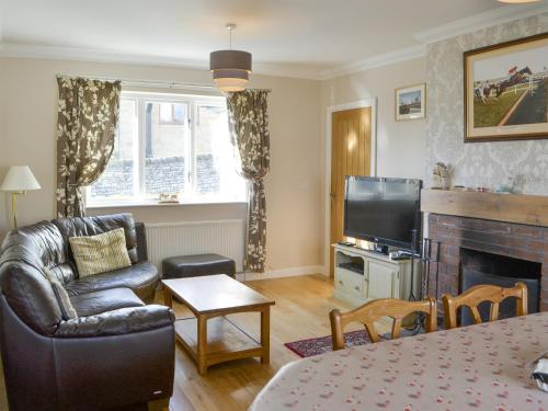 a living room with a couch and a television at Heatherlea in Otterburn