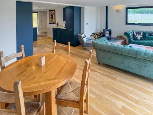 a living room with a table and a couch at Fernhill Stables in Sevenoaks