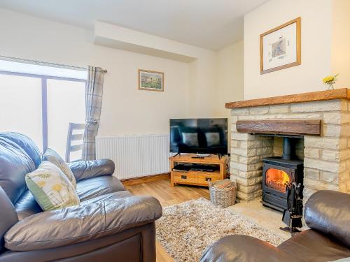 a living room with a couch and a fireplace at Shepherd's Nook - Uk32388 in Dunford Bridge