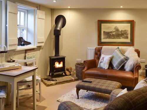 a living room with a fireplace and a couch at The Old Cobblers Cottage in Bakewell
