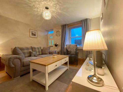 a living room with a couch and a table at Heather Cottage in Lauder