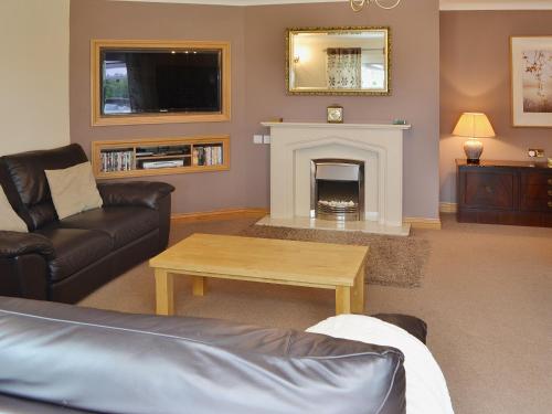 a living room with a couch and a fireplace at The Willows Red Row in East Chevington