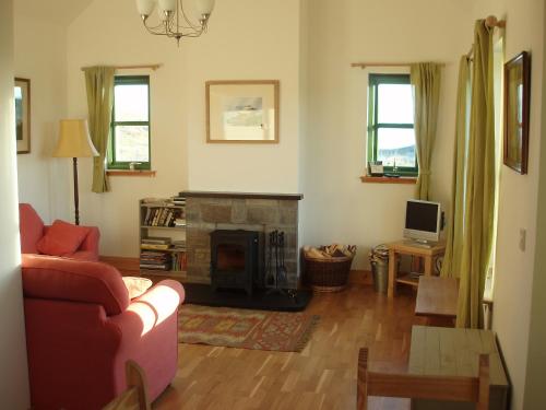 a living room with a couch and a fireplace at Taigh Uaine in Culkein