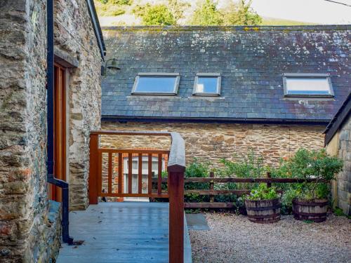 a house with a wooden gate and a building with windows at Mill Balcony in Ashsprington