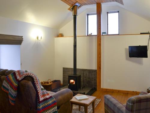a living room with two couches and a fireplace at Tawmans in Kilmuir