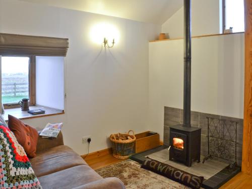 a living room with a couch and a fireplace at Tawmans in Kilmuir