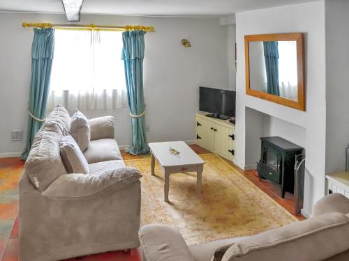 a living room with two couches and a table at Newbiggin Cottage in Richmond