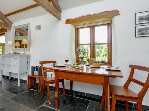a dining room with a wooden table and chairs at Old Dairy in Chulmleigh
