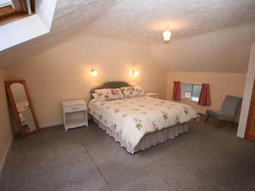 a bedroom with a bed and a mirror at Halliday Hill Cottage in Dalton