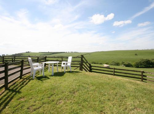 two white chairs and a table on a fence at Halliday Hill Cottage in Dalton