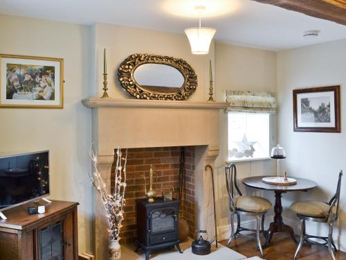 a living room with a fireplace and a mirror at Mill Race Cottage in Bakewell