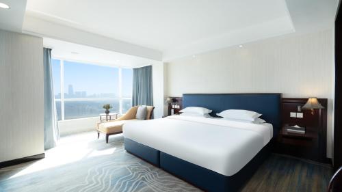 a bedroom with a large bed and a large window at Shunde Grand View Hotel in Shunde