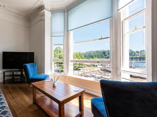 a living room with a table and two chairs and windows at Anchorage View in Dartmouth