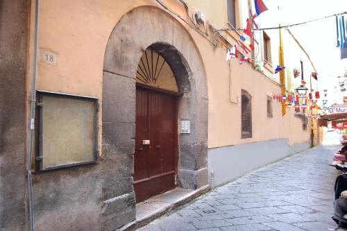 Une allée avec une porte marron et des drapeaux sur un bâtiment dans l'établissement Vivaldo Suite - Accademia, à Sorrente