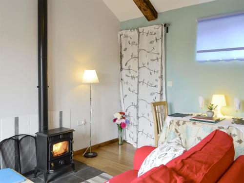 a living room with a couch and a wood stove at Shepherdskirk in Kyloe
