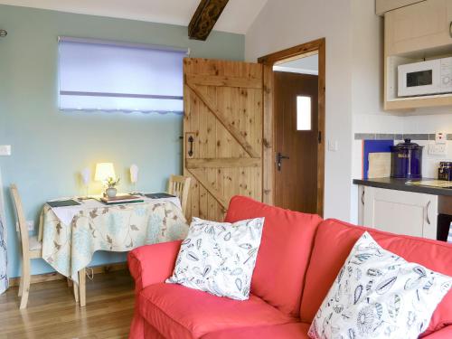 a living room with a red couch and a table at Shepherdskirk in Kyloe