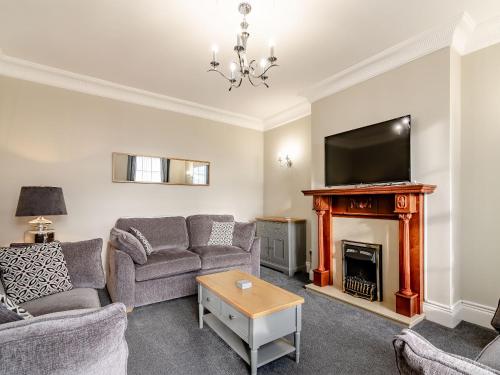 a living room with a couch and a fireplace at Wold House Cottage in Nafferton