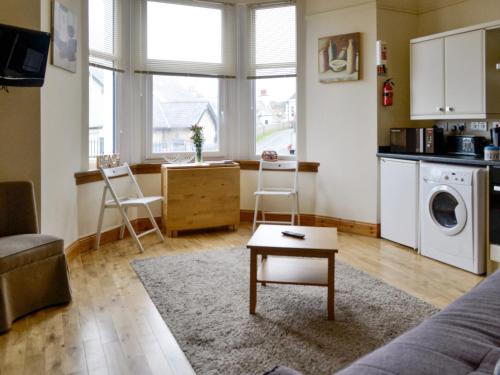 a living room with a couch and a table and a kitchen at Dorn Rock View - Uk33918 in Portpatrick