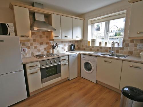 a kitchen with white cabinets and a washer and dryer at New Bakery in Glanton