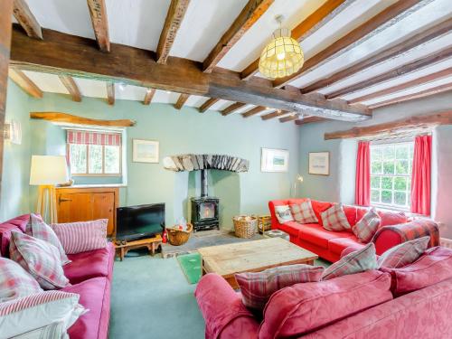 a living room with red couches and a fireplace at Thwaite Bridge Houseconiston in Coniston