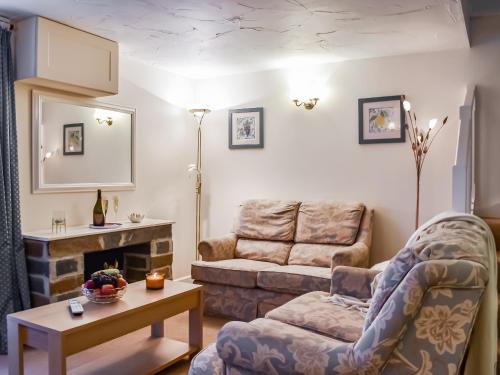 a living room with a couch and a chair at Cowshed - Uk49024 in Liskeard