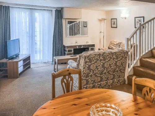 a living room with a couch and a table at Cowshed - Uk49024 in Liskeard