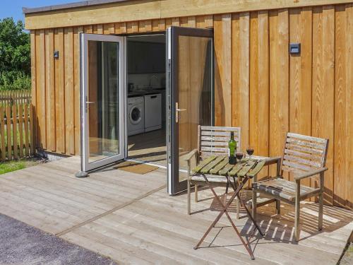 a patio with a table and chairs and a house at Bueno - Ukc4682 in Clynnog-fawr