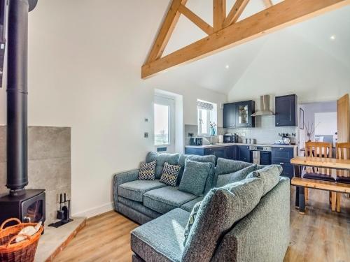 a living room with a couch and a stove at The Cowshed - Uk37349 in Hockerton