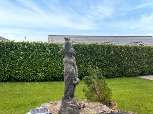 a statue of a person with a bear on its shoulder at The Farmhouse - Uk49068 in Liskeard
