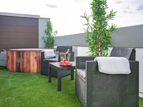 a patio with chairs and a table on grass at Das Penthouse mit 3 Dachterrassen, Whirlpool & Panoramablick in Karlsruhe