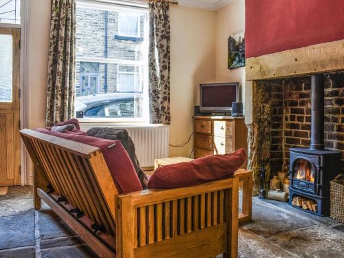 a living room with a couch and a wood stove at Limestone Cottage in Hebden Bridge