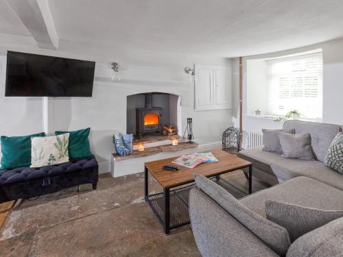 a living room with two couches and a fireplace at Hurst Cottage in Sturminster Newton