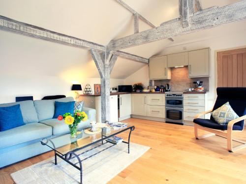 ein Wohnzimmer mit einem blauen Sofa und einem Tisch in der Unterkunft Alpaca Cottage in Frampton