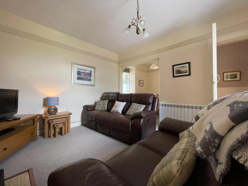 a living room with a couch and a television at Birch Cottage - Uk38992 in Dalcross