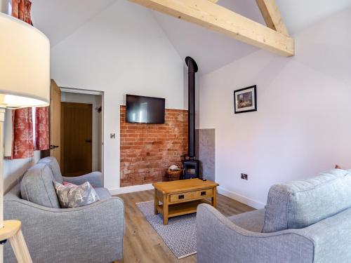 a living room with two chairs and a fireplace at The Piggery - Uk37348 in Hockerton