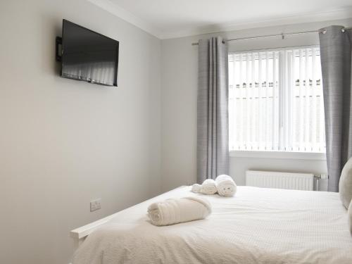 a bedroom with a bed with two towels on it at Cathwill in Newtonmore