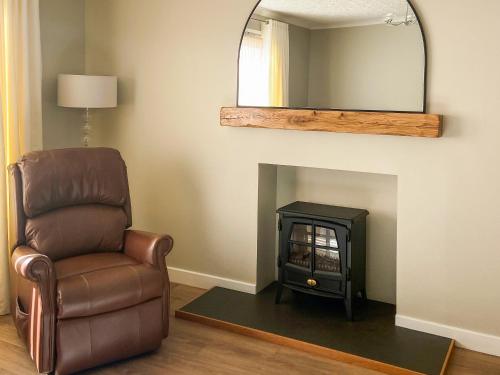 a living room with a chair and a mirror at Cathwill in Newtonmore