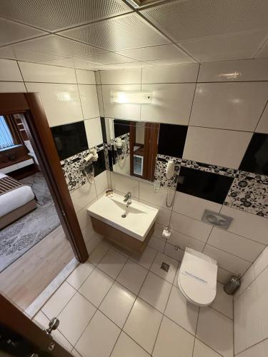 a bathroom with a sink and a toilet and a mirror at My Liva Hotel in Kayseri